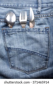 Hungry Man Carries A Fork, Spoon And Knife Into The Back Pocket Of Jeans For A Snack