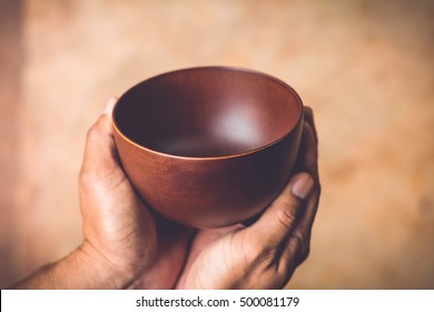 a hungry man holding an empty bowl