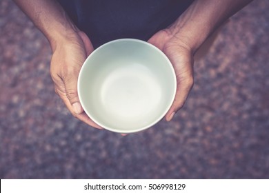 A hungry man holding an empty bowl