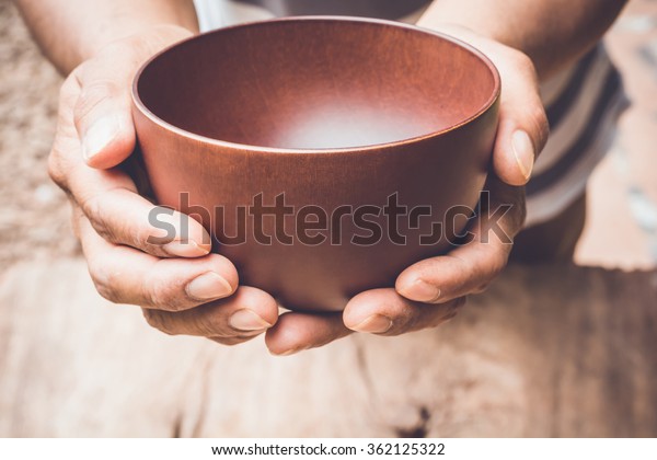 a hungry man holding an\
empty bowl