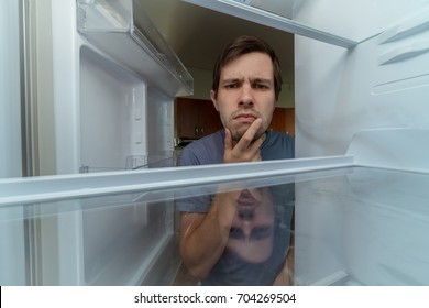 Hungry Man Is Looking For Food In Empty Fridge.