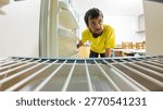Hungry man looking inside empty refrigerator for food