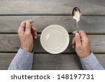 Hungry man waiting for his meal over empty bowl on wooden table. 