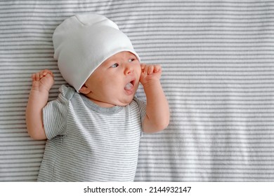 A Hungry Newborn. A Baby Laying On A Striped Nappy With Tongue Out Asking For Milk. Baby Care.