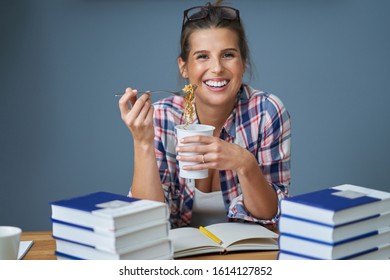 Hungry Student Eating Noodle While Learning At Home