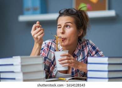 Hungry Student Eating Noodle While Learning At Home