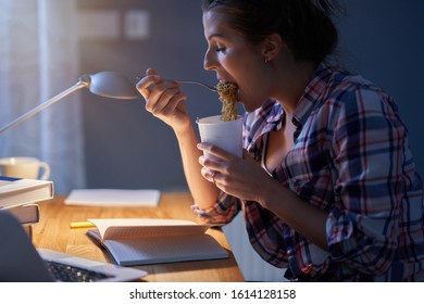 Hungry Student Eating Noodle While Learning At Home