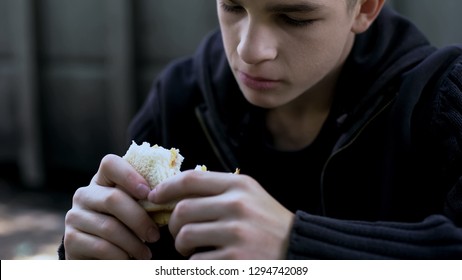 Hungry Teen Boy Eating Cheap Unhealthy Sandwich, Poor Quality Meal For Child