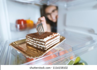 Hungry Woman Eating A Dessert Straight From The Fridge Using A Fork, Diet Fail Concept