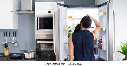 Hungry Women Looking At Food Inside Fridge