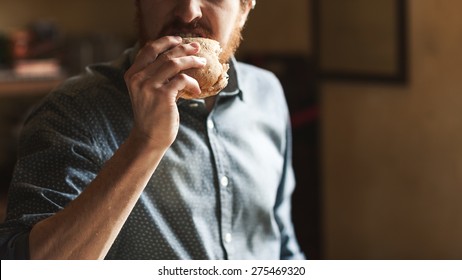 Hungry Young Hipster Man Eating A Tasty Sandwich With Ham, Hand Close Up