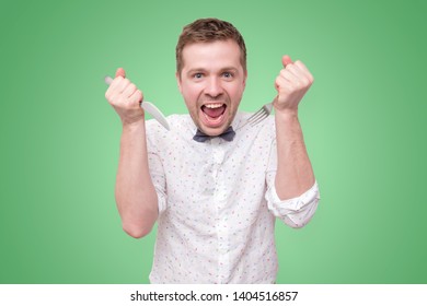 Hungry Young Man Holding Fork And Knife On Hand Ready To Eat. Diet And Healthy Foo Concept.