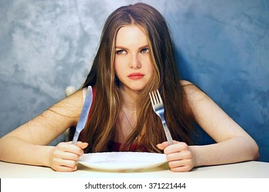 Hungry Young Woman Waiting With An Empty Plate.