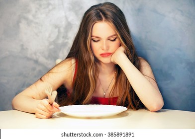 Hungry Young Woman Waiting With An Empty Plate.