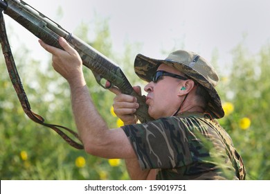 Hunter Aims And Shoots Dove Flying Overhead During Hunting Season.  Hunting Season Begins In September (autumn, Fall) In Texas. Color, Horizontal Image With Room For Copy.