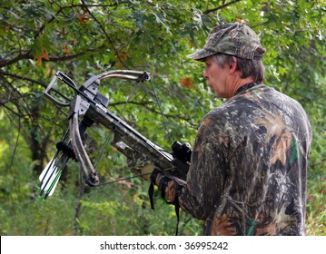 hunter in camouflage holding a crossbow - Powered by Shutterstock