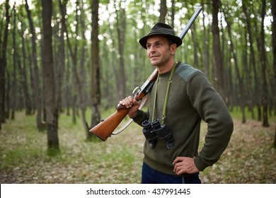 Hunter with double barrel shotgun in the forest