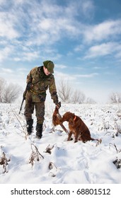 Hunter getting the pheasant from the dog during a winter hunting party. General open season scene