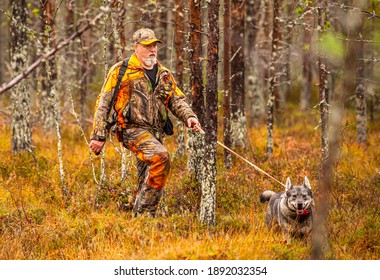 Hunter and his elkhound outdoor in the wilderness