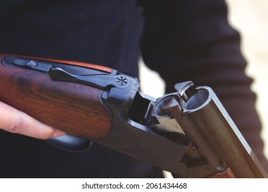 Hunter loads a double-barreled shotgun, close-up. The concept of self-defense and attack