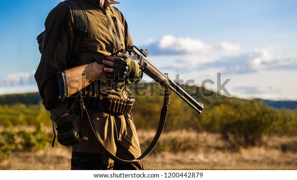 Hunter man. Hunting period, autumn season. Male with a\
gun. A hunter with a hunting gun and hunting form to hunt in an\
autumn forest. The man is on the hunt. Hunter with a backpack and a\
hunting gun. 