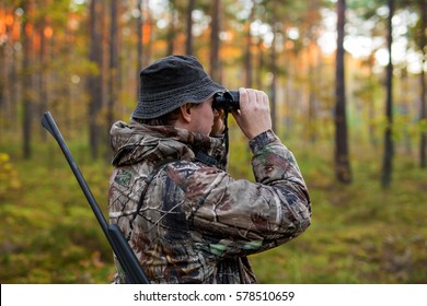 Hunter Observing Forest With Binoculars