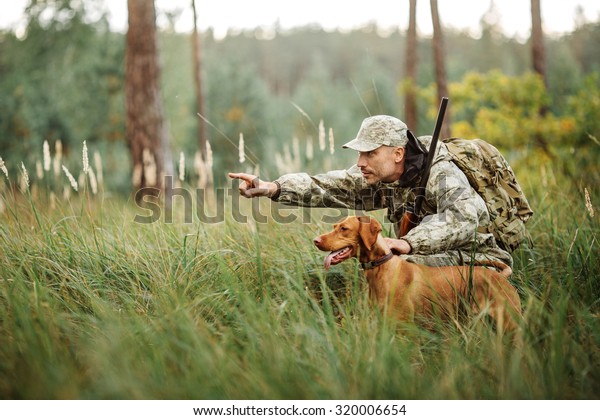 Hunter with Rifle and Dog in\
forest