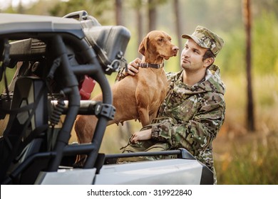 Hunter With Rifle And Four Wheeler Tire In Fall Forest