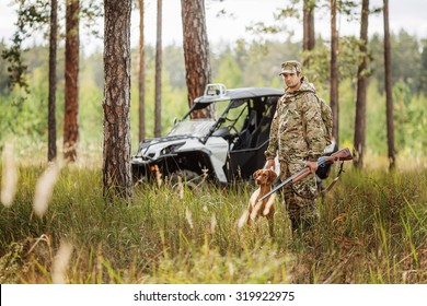 Hunter With Rifle And Four Wheeler Tire In Fall Forest