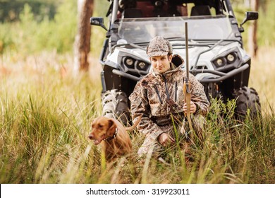 Hunter With Rifle And Four Wheeler Tire In Fall Forest