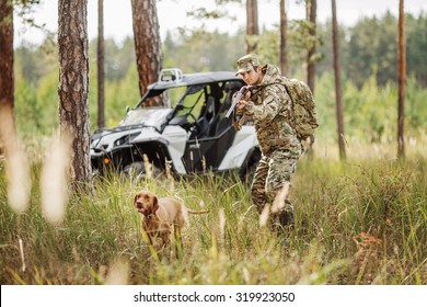 Hunter With Rifle And Four Wheeler Tire In Fall Forest