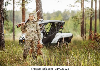 Hunter With Rifle And Four Wheeler Tire In Fall Forest