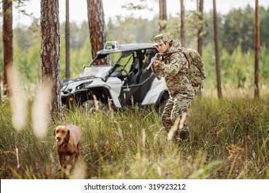 Hunter With Rifle And Four Wheeler Tire In Fall Forest