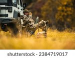 Hunter Seating Next to His All Wheel Drive Vehicle and Drinking Hot Coffee From His Thermos