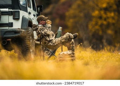 Hunter Seating Next to His All Wheel Drive Vehicle and Drinking Hot Coffee From His Thermos - Powered by Shutterstock