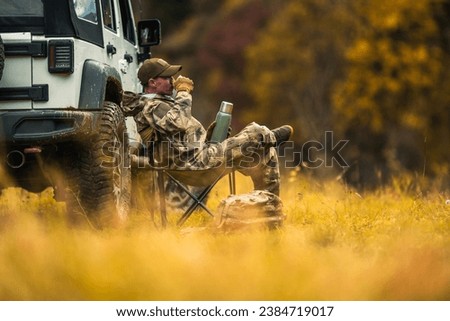 Hunter Seating Next to His All Wheel Drive Vehicle and Drinking Hot Coffee From His Thermos [[stock_photo]] © 
