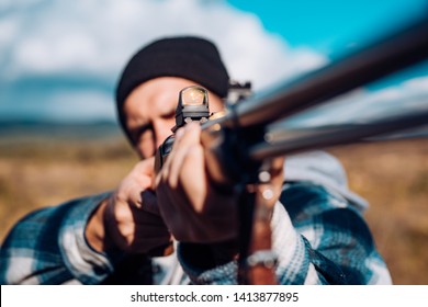 Hunter Target With Laser Sight. Collimating Sight. Hunter With Shotgun Gun On Hunt. Hunter Target With Laser Sight. Hunter Aiming Rifle In Forest. Poacher In The Forest