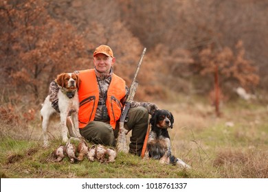 hunter with two hunting dogs, a gun and a woodcock after a hunt