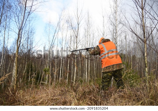 Hunter while\
hunting wild animals. Hunters with gun and rifle on hunting in the\
fall season. Hunter during hunting in forest. Hunters track down a\
wild boar or elk in the\
forest.\
