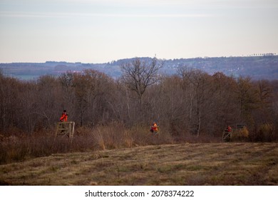 hunters in orange coats wait and sit on high seats near Marche in belgian ardennes duiring hunting party in the fall