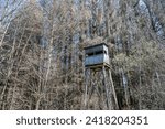 A hunters seat in the woods surrounded by trees in winter. Seen in a German forest