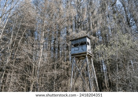 A hunters seat in the woods surrounded by trees in winter. Seen in a German forest
