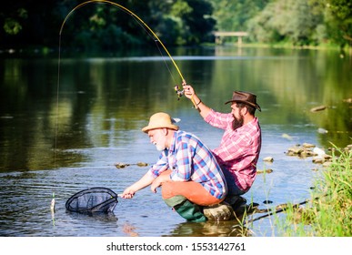 Hunting. Happy Fishermen Friendship. Catching And Fishing. Two Male Friends Fishing Together. Retired Dad And Mature Bearded Son. Fly Fish Hobby Of Men In Checkered Shirt. Retirement Fishery.