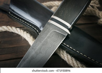 hunting knife handmade on a brown wooden background