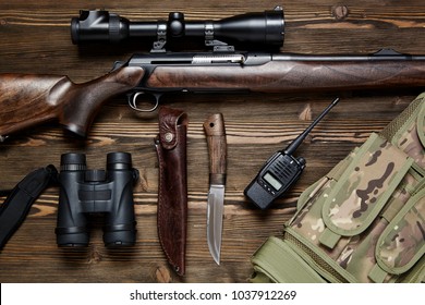 Hunting rifle and ammunition on a dark wooden background.Top view.