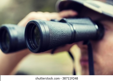 hunting, war, army and people concept - close up of young soldier, ranger or hunter with binocular observing forest - Shutterstock ID 387119248