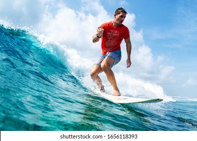 HURAA , MALDIVES MARCH 10, 2019: Hispanic young man surfs the wave on the Sultans surf spot in Maldives