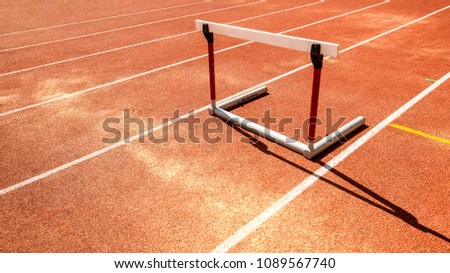 hurdle race barrier obstacle on red  running track , athletic stadium