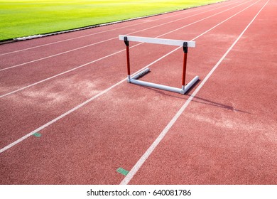 hurdle race barrier on red  running track , athletic stadium
 - Powered by Shutterstock