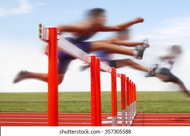 Hurdle race, men jumping over hurdles in a track and field race. Motion blurred image, digitally altered unidentifiable face. - Shutterstock ID 357305588
